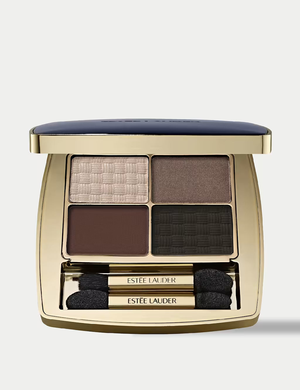 Estee Lauder Quad Eye Shadow Gallery Hop compact in a gold case with a navy blue lid, shown open to reveal four textured eyeshadow pans in beige, brown, black, and taupe, with two applicators below.