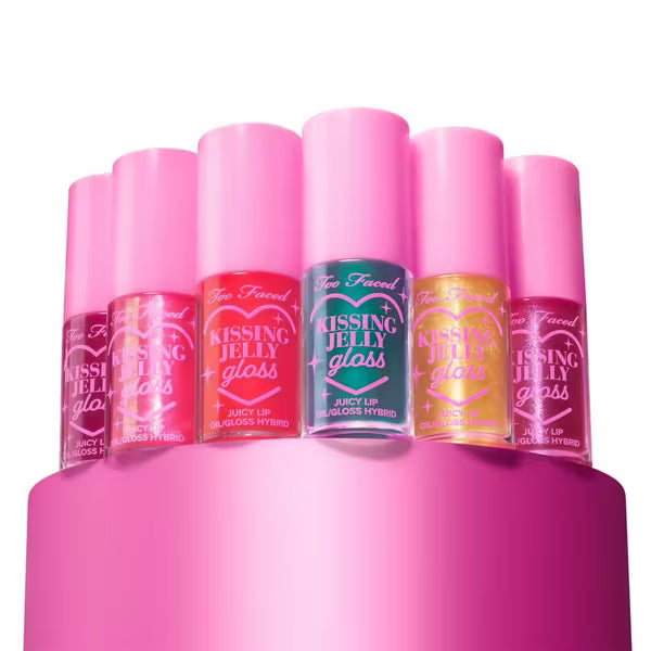 Set of Too Faced Kissing Jelly Gloss lip glosses on a pink stand with a white background